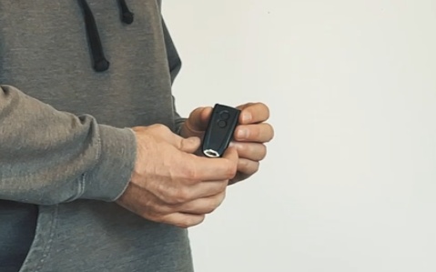 Garagentorantrieb Test & Vergleich | Der beste Antrieb? 12 Person hält einen Handsender für den EcoStar Liftronic Antrieb in der Hand