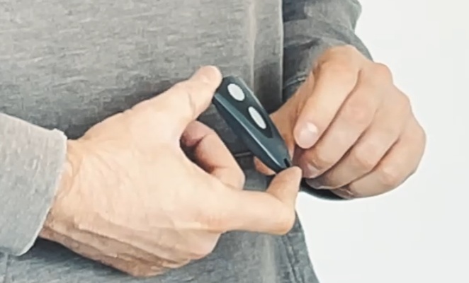 Garagentorantrieb Test & Vergleich | Der beste Antrieb? 36 Person hält einen Handsender zum Bedienen des Run 500 in der Hand