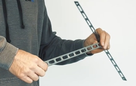 Garagentorantrieb Test & Vergleich | Der beste Antrieb? 21 Personn hält zwei Deckenabhänger des Torado C51 Antriebs in der Hand
